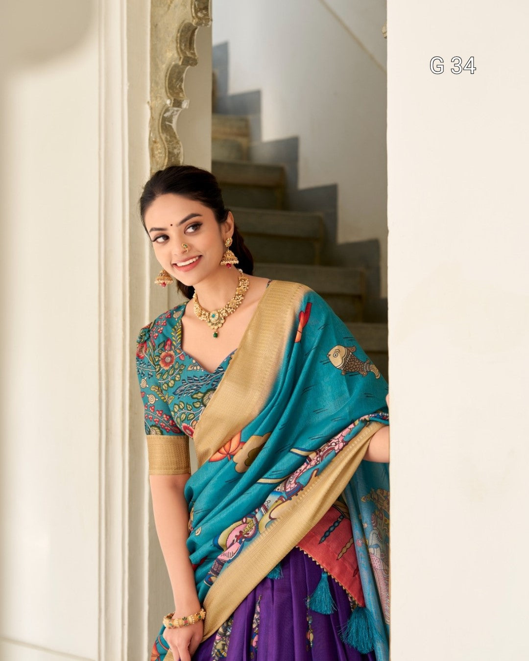 Woman in a traditional saree standing in a staircase