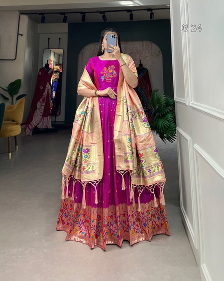 Person wearing a traditional outfit with a pink and gold color scheme in a room.