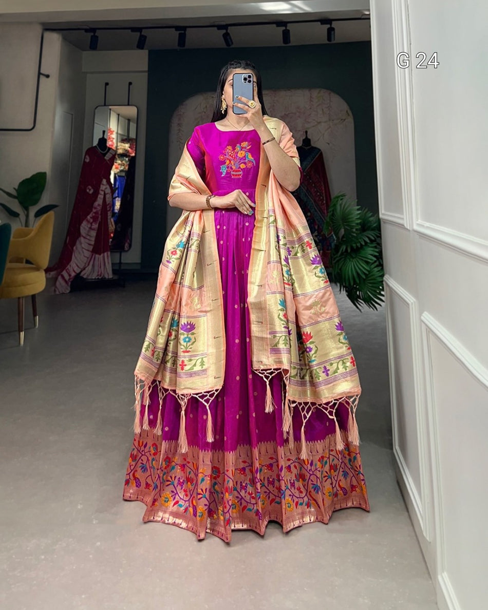 Person wearing a traditional outfit with a pink and gold color scheme in a room.