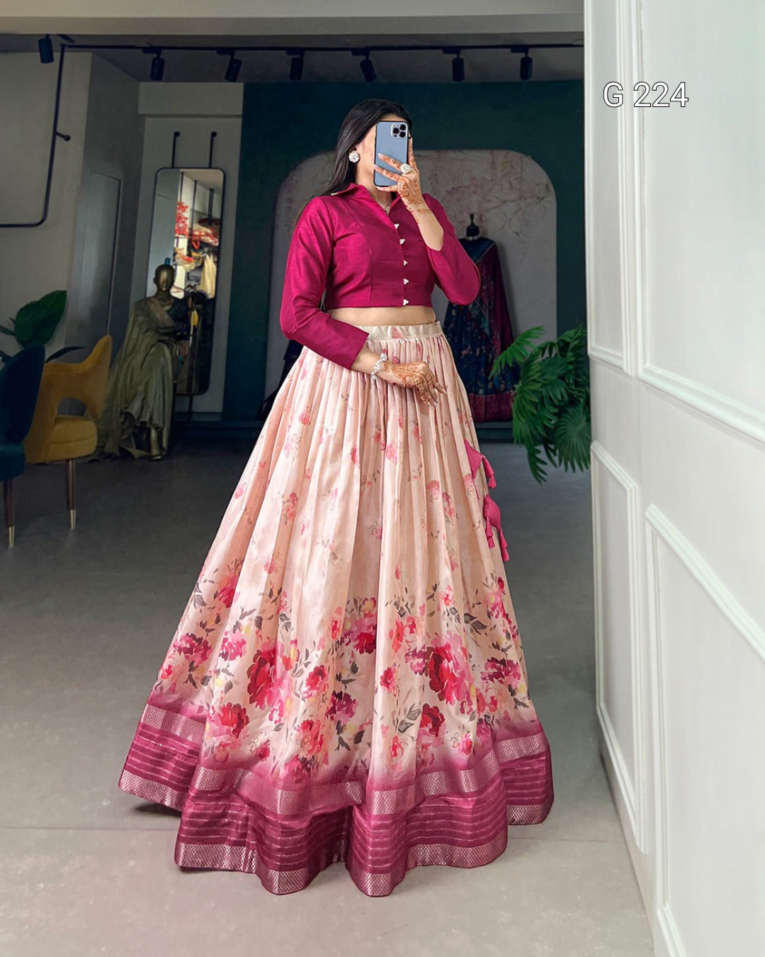Person wearing a pink floral lehenga with a matching blouse in a room.