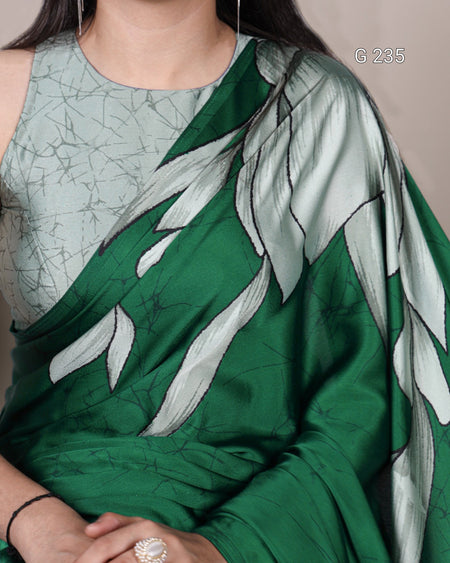 Green saree with leaf patterns worn by a person, on a neutral background.