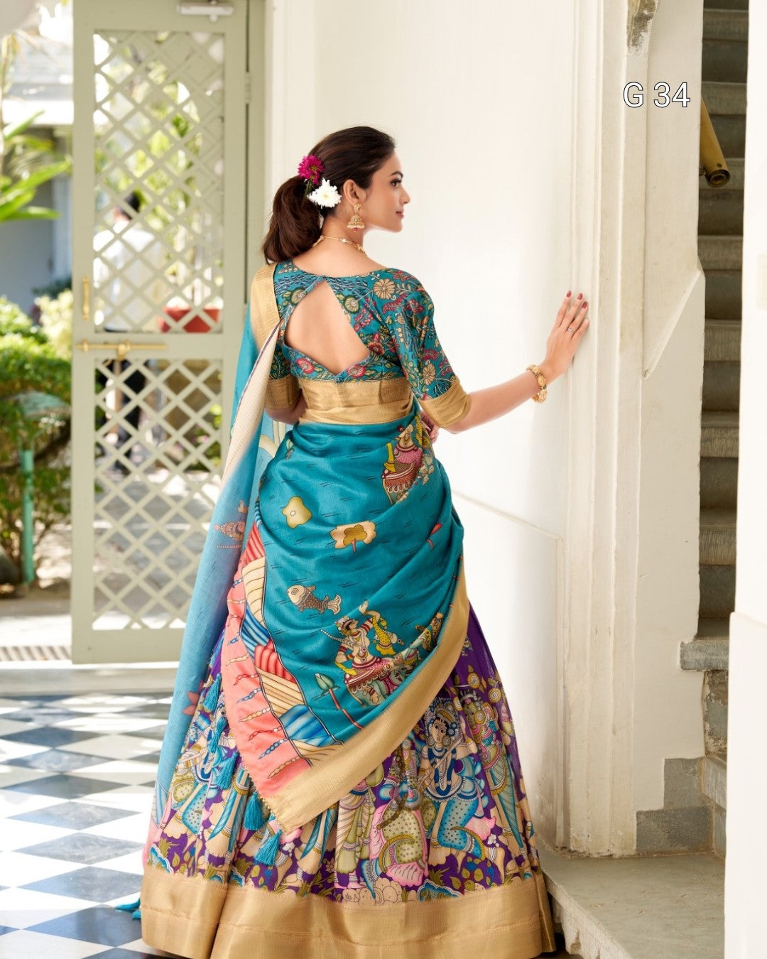 Woman in a traditional colorful saree standing indoors.