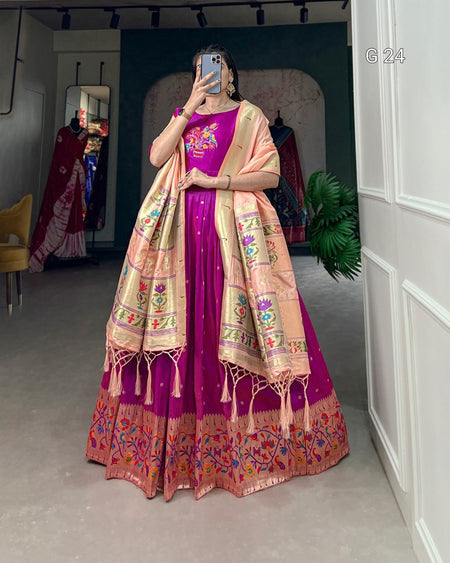 Person wearing a traditional outfit with a pink and beige dress and dupatta in a room.
